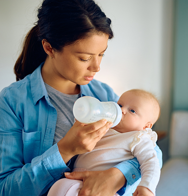 Young mother using baby bottle