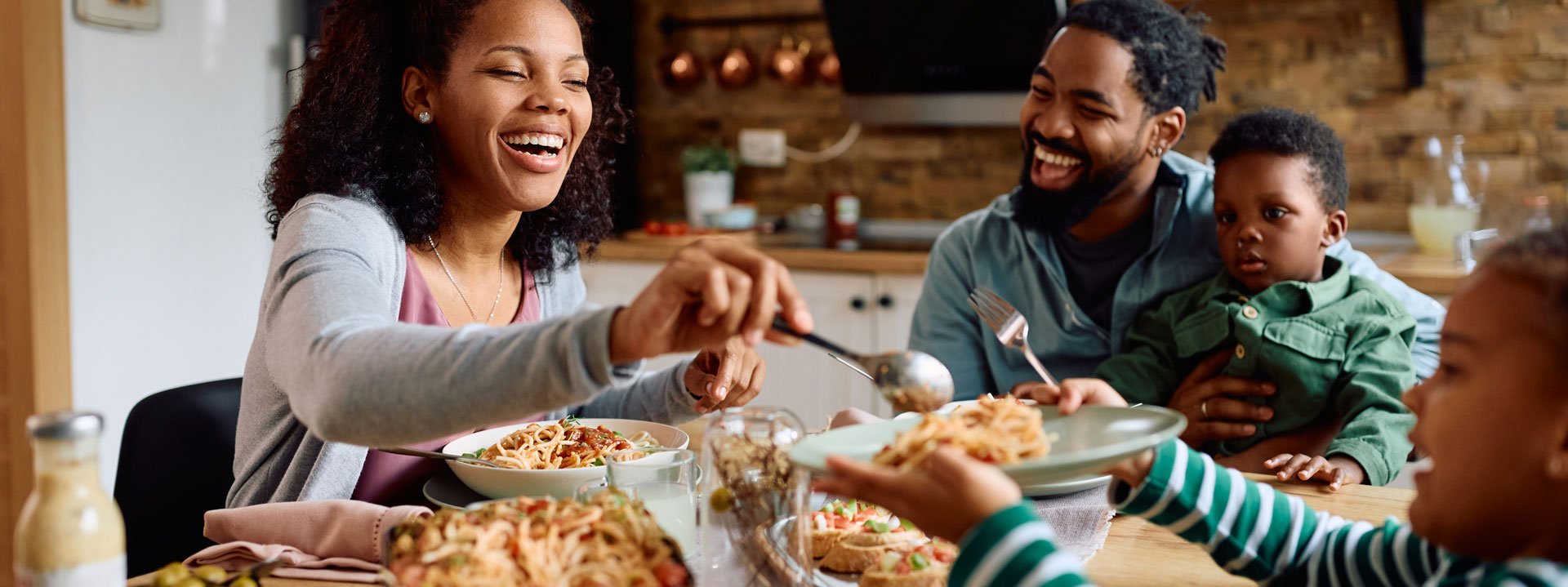 Family sharing mealtime, smiling and passing dishes